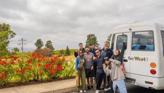 Happy group posing with Go West Tours van