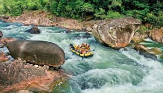 Barron River Rafting A raft full of people paddling through the Tully River