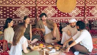 Bedouin Culture Safari Guests enjoying traditional food and company during the Bedouin Culture Safari in Dubai