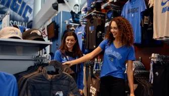 Orlando Magic Two people smiling while shopping in the Orlando Magic team store