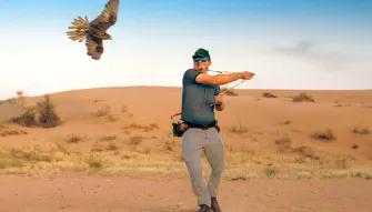 Man smiling with a falcon at Platinum Desert Safari Dubai