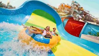 Yas Waterworld Abu Dhabi Two children having fun riding a shared inflatable tube at Yas Waterworld Abu Dhabi