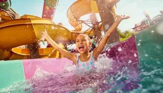 Yas Waterworld Abu Dhabi Happy child having fun with arms raised on a water attraction at Yas Waterworld Abu Dhabi
