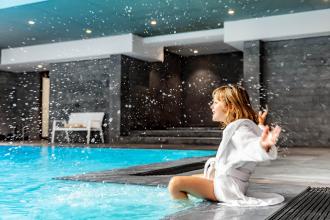 Woman next to indoor pool at Relais Spa Val d'Europe 