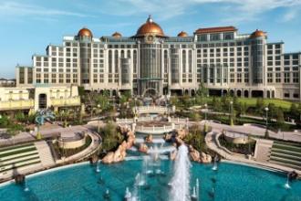 The impressive Universal Helios Grand Hotel with greenery in front of the hotel and a huge water fountain in the foreground