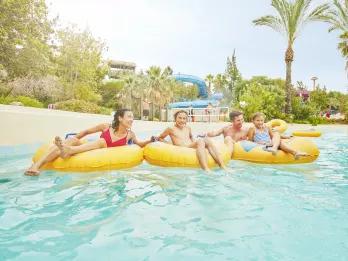 Family riding along El Rio Loco lazy river at PortAventura Caribe Aquatic Park