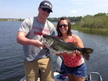Trophy Bass Fishing Two people smiling as they hold a fish they have caught.