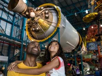 Father and daughter viewing giant rockets at Kennedy Space Center
