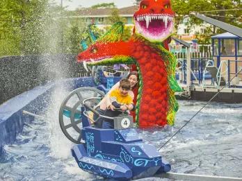 Hydra's Challenge A woman and child getting splashed in a boat ride vehicle in front of a giant Lego sea serpent