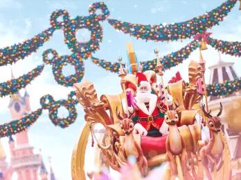 Santa Claus on a parade float being pulled by mechanical reindeer, with Mickey Mouse wreaths and Sleeping Beauty Castle in the background