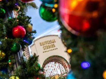 The Universal Studios Hollywood entrance decorated for Christmas with garlands and baubles