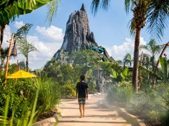 Universal's Volcano Bay Water Park A child in a wetsuit walking along a path lined with plants towards the volcano at Volcano Bay