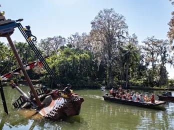 Pirate River Quest A boat on a waterway sailing past a half sunken LEGO pirate ship