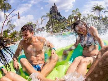 Guests splasing down at the end of the water raft ride Honu at Universal's Volcano Bay