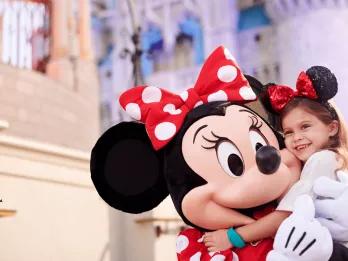 Disney Bands at Walt Disney World A young girl hugging Minnie Mouse in front of Cinderella Castle at Walt Disney World