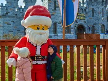 A boy and a girl looking up at LEGO Santa