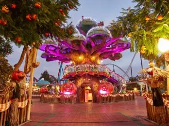 Halloween at PortAventura A large cartoon style tree decorated with sparkling lights and pumpkins