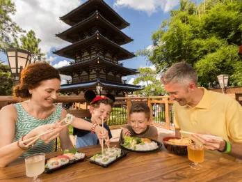 EPCOT A family sat at a table eating sushi in front of a traditional Japanese building