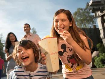 Disney's Hollywood Studios A young boy and girl eating popcorn and laughing with their parents in the background