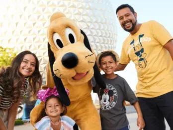 Familie steht mit Goofy vor dem Spaceship Earth in EPCOT