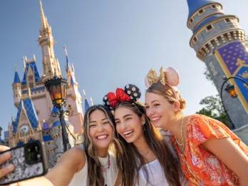 Drei Frauen stehen vor dem Cinderella Schloss im Magic Kingdom Park im Walt Disney World Resort in Florida