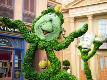 EPCOT International Flower and Garden Festival Plant sculpture of the cartoon characters of a grandfather clock with a cartoon face and a candlestick with a cartoon face from Disney's Beauty and the Beast.