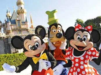 Micky, Minnie und Goofy posieren vor dem Dornröschenschloss in Disneyland Kalifornien
