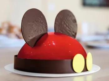 A red glazed cake with two ears to look like Mickey Mouse