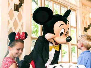 Two children meeting Mickey Mouse in a restaurant 