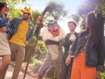 A group of young adults posing with Rafiki from The Lion King