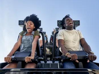 VelociCoaster in Universal Islands of Adventure  Two people screaming on a rollercoaster with only lap bars holding them in. They are looking down in shock ready to fall.
