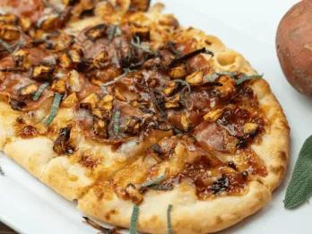 Herbstpizza Eine lange Pizza, belegt mit herbstlichen Zutaten