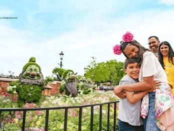 Springtime in Walt Disney World Resort A boy and girl hugging next to topiaries of the seven dwarves from Snow White