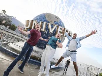 Universal Orlando Resort Three people jumping excitedly in front of the Universal Globe