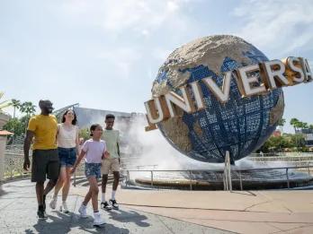 Universal Orlando Resort A family walking in front of the Universal globe at Universal Orlando Resort
