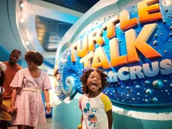 Turtle Talk with Crush A child smiling with excitement in front of a sign reading Turtle Talk with Crush
