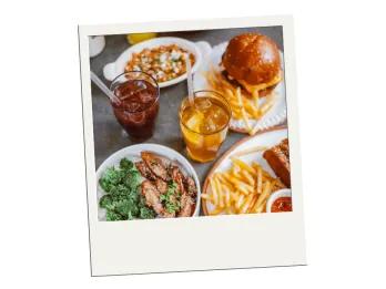 Budget Dining in Orlando A polaroid image of plates of burgers and fries, stir fry and steak on a table