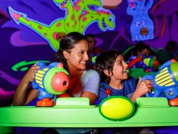 Buzz Lightyear's Space Ranger Spin A mother and sun in a neon green ride vehicle using plastic laser blasters to shoot targets