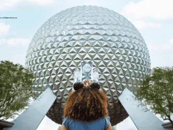 EPCOT at Walt Disney World Resort A young girl wearing Minnie ears facing towards Spaceship Earth at EPCOT
