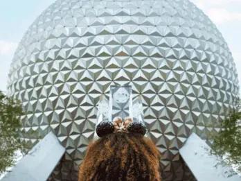 Spaceship Earth in EPCOT Mädchen mit Micky Ohren steht vor dem Spaceship Earth im Freizeitpark EPCOT in Orlando