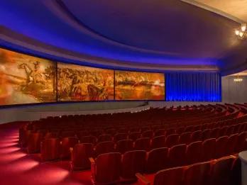 Hall of Presidents An empty theatre with rows of red seats in front of a large curved screen