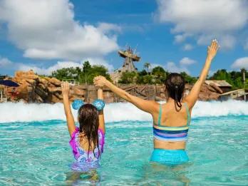 Surf Pool at Disney's Typhoon Lagoon Water Park A mother and daughter waiting for a wave to hit them in a water park wave pool