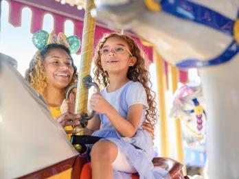 Prince Charming Regal Carrousel A girl and her mother riding a traditional carrousel