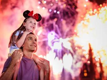 Magic Kingdom After Hours A girl sat on her dad's shoulders while watching the fireworks above Cinderella Castle