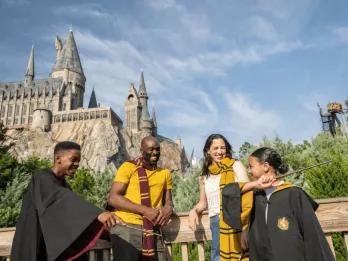 A family in Harry Potter robes outside Hogwarts Castle