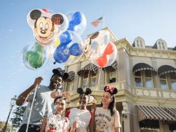 A family holding Mickey Mouse shaped balloons on Main Street USA