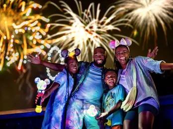 Nighttime Experiences at Walt Disney World A family posing in front of a fireworks display