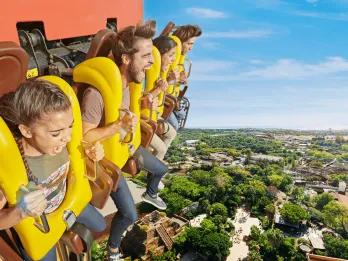 People waiting at the top of a drop tower about to drop