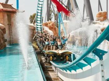 A rollercoaster car coming down a drop into a splash of water