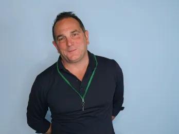 Meet our CEO Man stood in front of a blue screen for a professional photo.